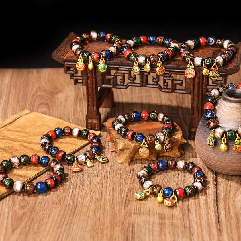 Multiple Five Elements Buddhist bracelets on carved wooden display stand – flat lay showcase of various bead sizes and charm styles