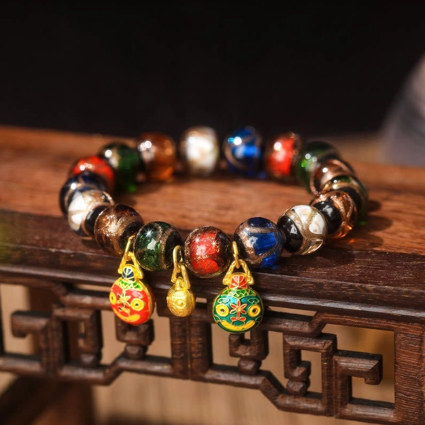 Feng Shui Five Elements Liuli glass bead bracelet with red and green enamel pendants and gold bell accent – prosperity charm close-up
