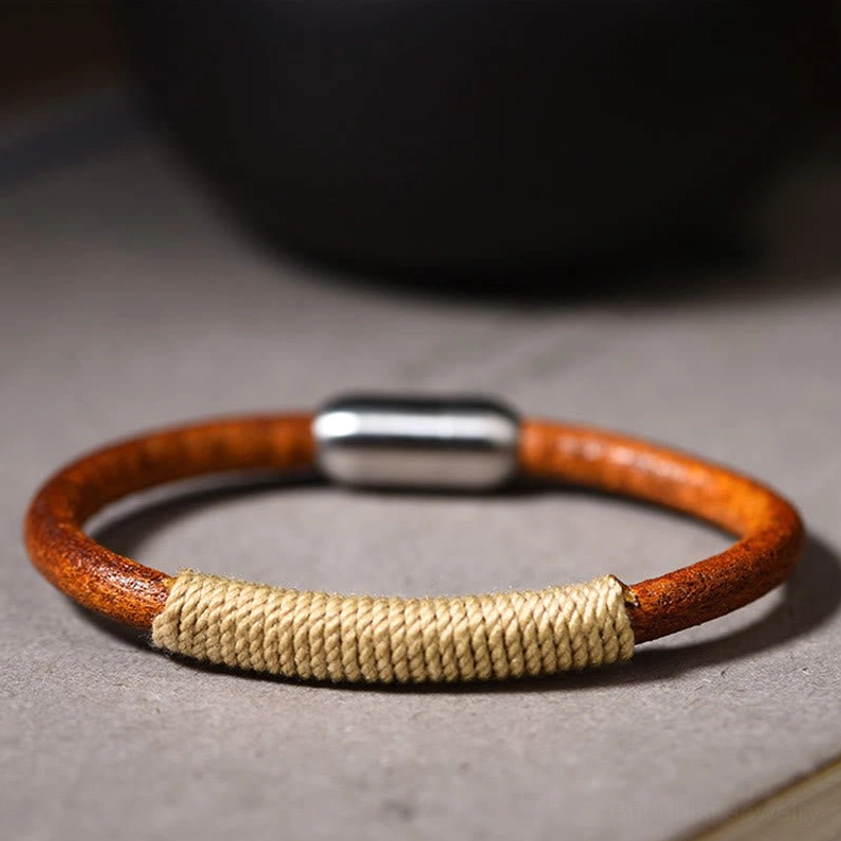 Beige metal five elements leather bracelet flat lay with silver magnetic clasp on grey surface