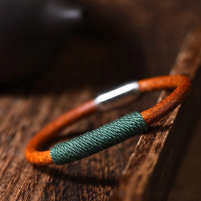 Green wood five elements leather braided bracelet with titanium steel magnetic clasp on wooden surface