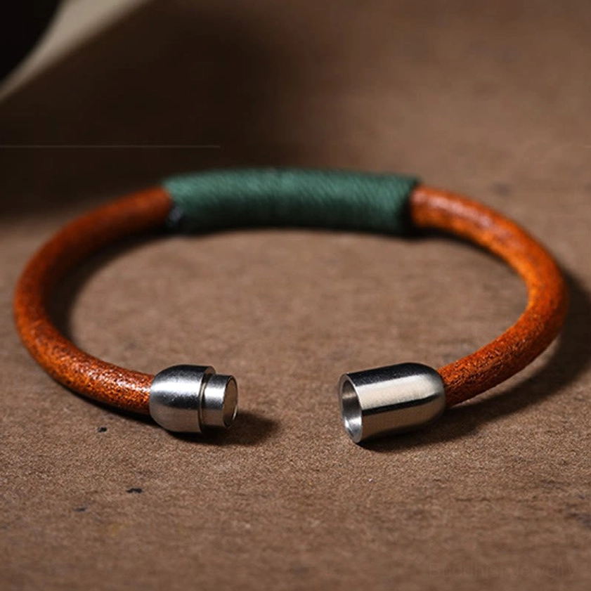 Five elements leather bracelet open cuff display showing dark green woven accent and dual magnetic buckles