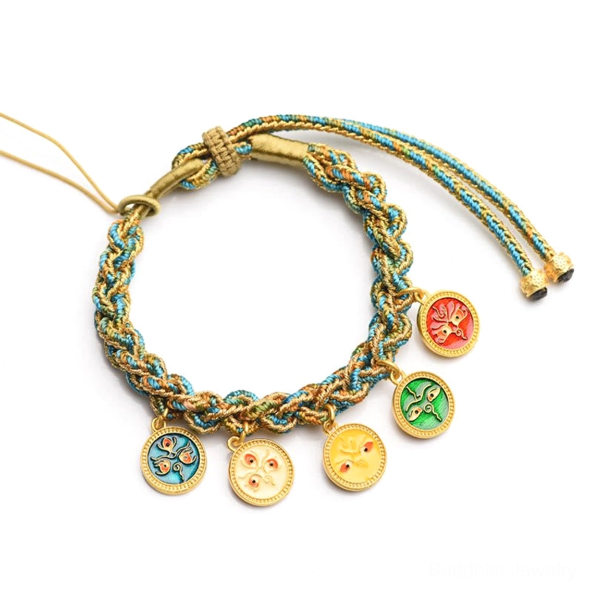 Five Gods of Wealth Buddhist string bracelet overhead flat lay with adjustable pull cord and four enamel gold prosperity charms on white background