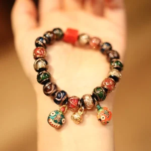 Five Gods of Wealth Buddhist bracelet with gold swallowing beast charm pendants and mixed colored ceramic beads on wrist