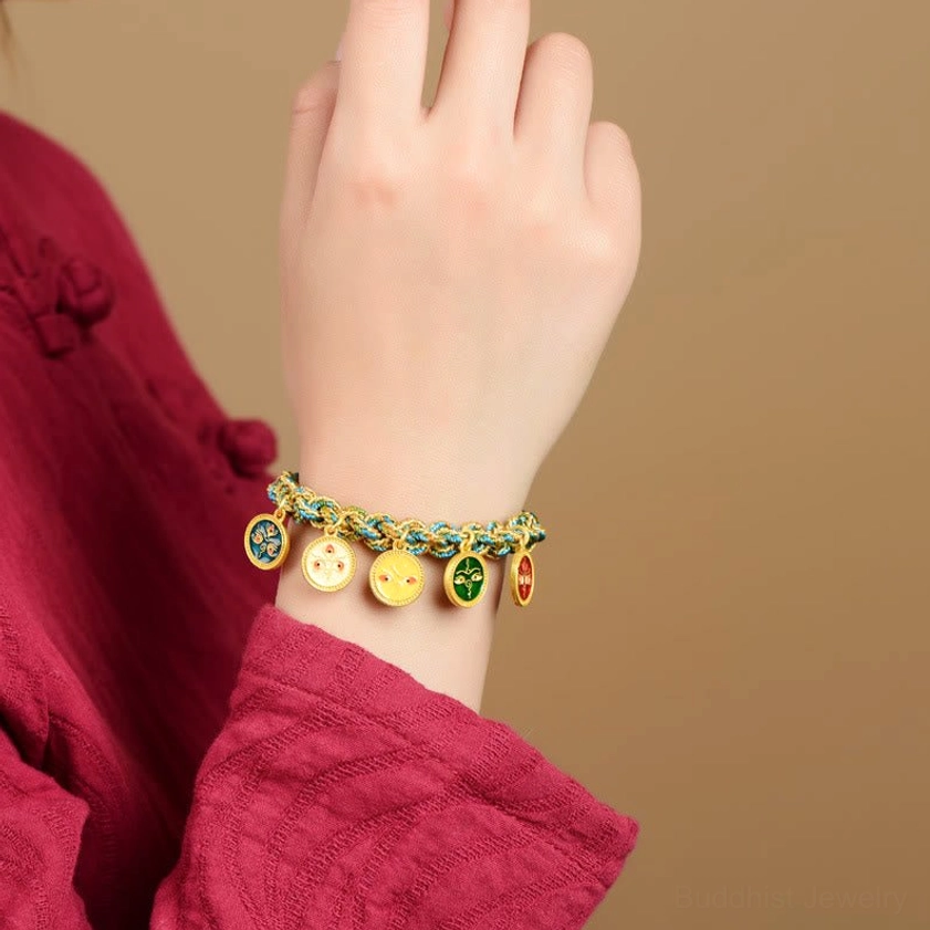 Five Gods of Wealth Buddhist prosperity bracelet worn on wrist lifestyle shot with mixed woven design on red textile background