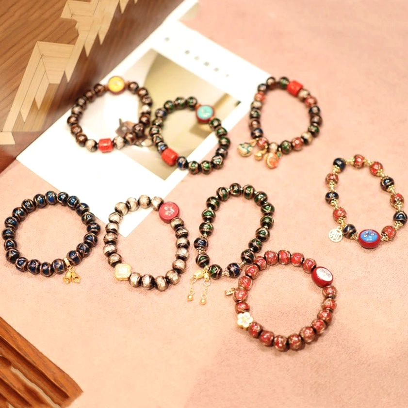 Multiple Five Gods of Wealth bracelet styles with mixed bead designs and gold-toned prosperity pendants flatlay