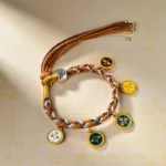 Five Gods of Wealth Buddhist multicolor string bracelet with five enamel charms displayed on beige background, showing intricate braided rope and metal tassel details