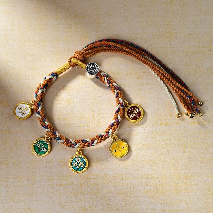 Handmade Buddhist wealth luck bracelet overhead view featuring five distinct colored enamel pendants on multicolor woven rope with adjustable tassel straps