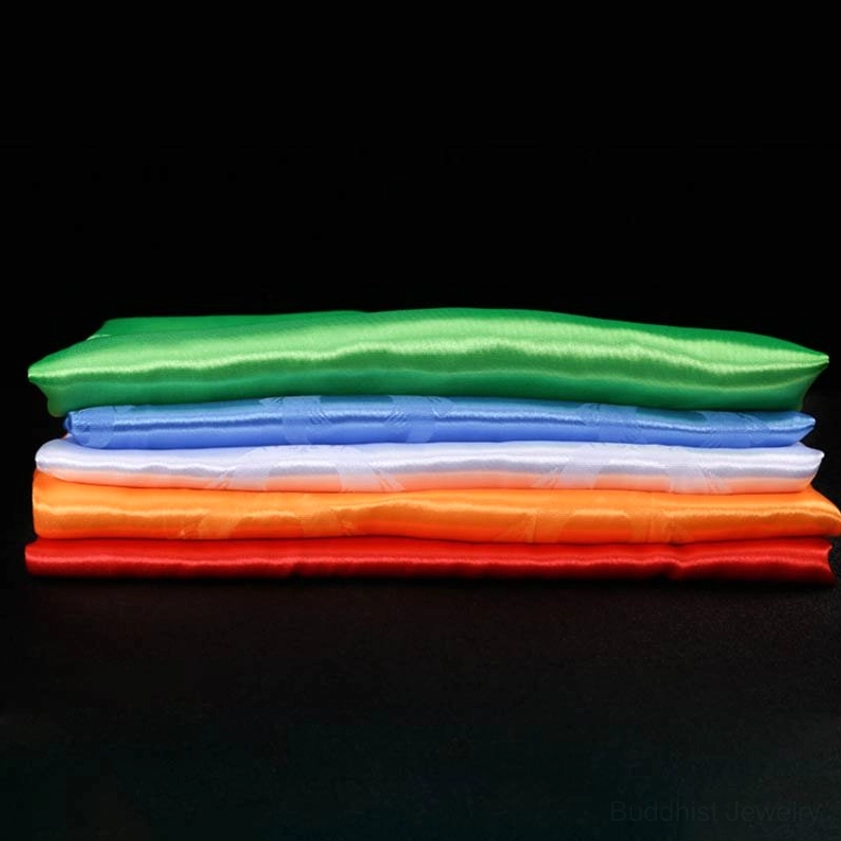 Five-color blessing khata scarves arranged showing all colors together with embossed auspicious Buddhist symbols and patterns