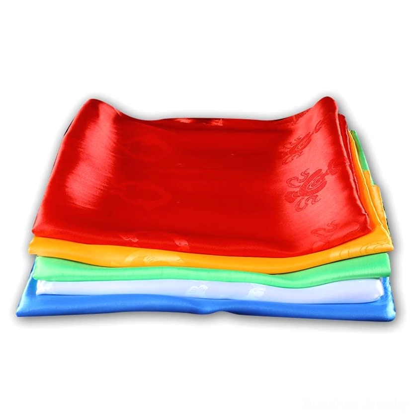 Stacked five-color khata scarf set in overhead view on white background showing smooth satin finish and embossed auspicious motifs