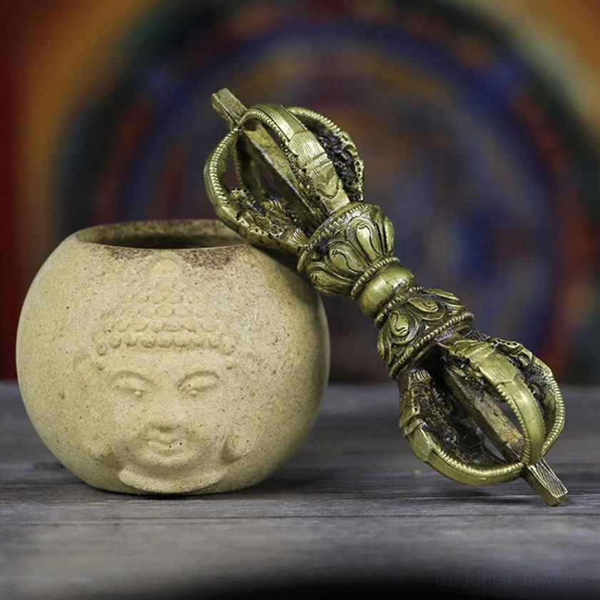 Handmade five-prong copper vajra dorje with dragon motifs, displayed on Buddhist altar with ceramic vessel