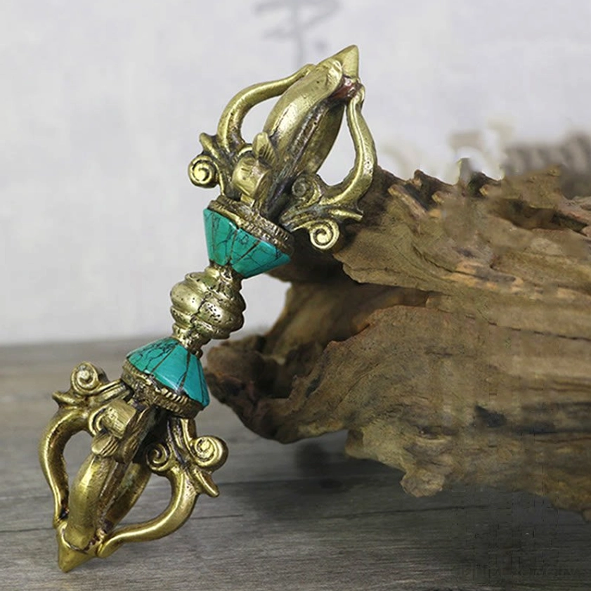 Five-prong vajra dorje displayed on driftwood with antique brass finish and turquoise stone inlays