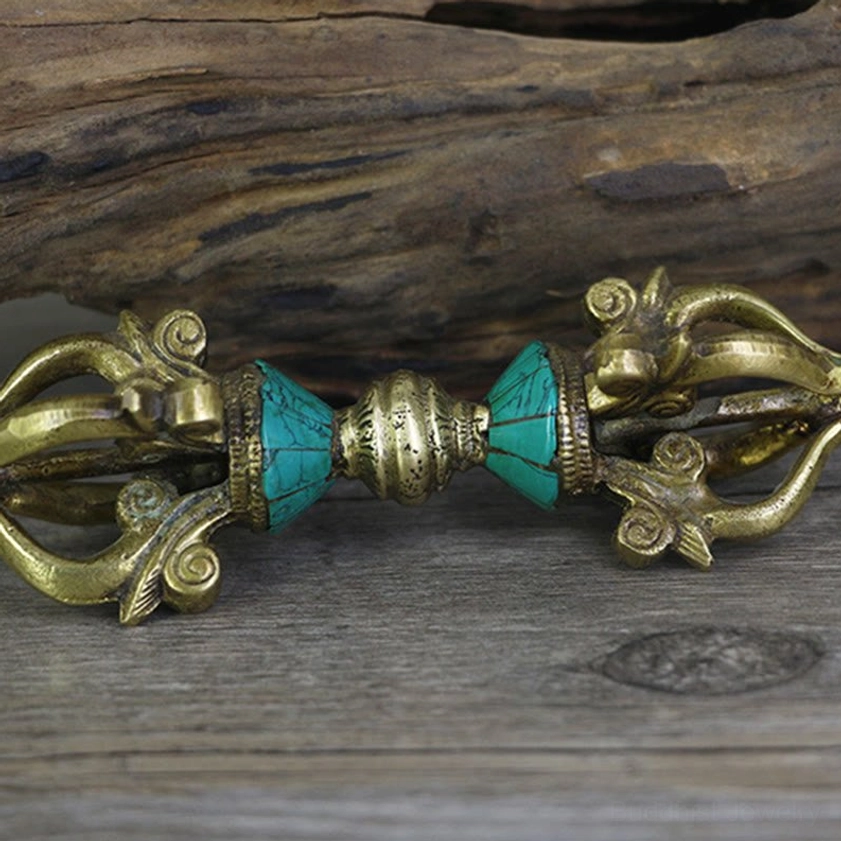Five-prong vajra dorje horizontal view highlighting matched turquoise inserts and carved prong ends