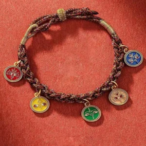 Five wealth deities braided string bracelet with multicolor enamel pendants on red fabric background - Buddhist prosperity charm