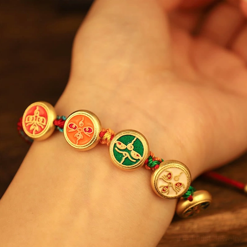 Five wealth deities bracelet worn on human wrist, first-person view showing multicolor braided rope with gold pendants