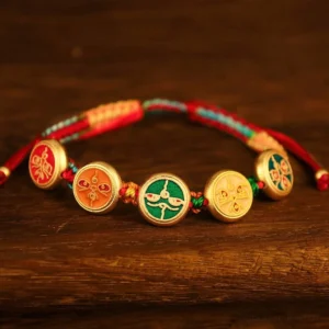 Five wealth deities braided Buddhist luck bracelet with multicolor woven rope and gold enamel charms showing traditional Buddhist iconography
