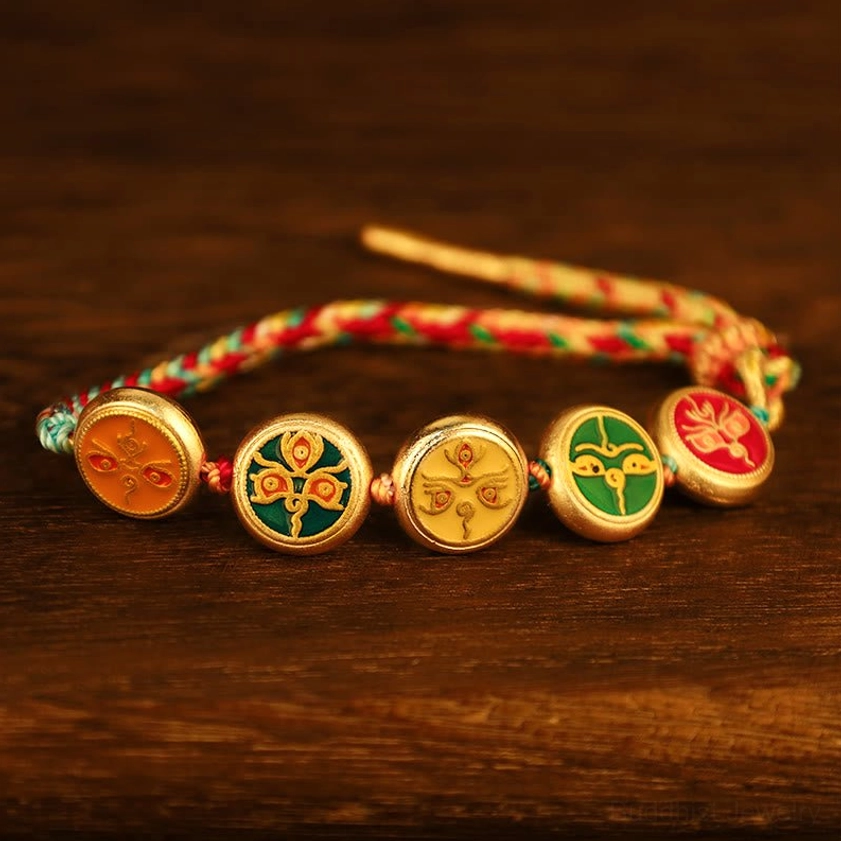 Five wealth deities braided Buddhist lucky bracelet with pull rope adjustment and multicolor woven cord on dark wooden background