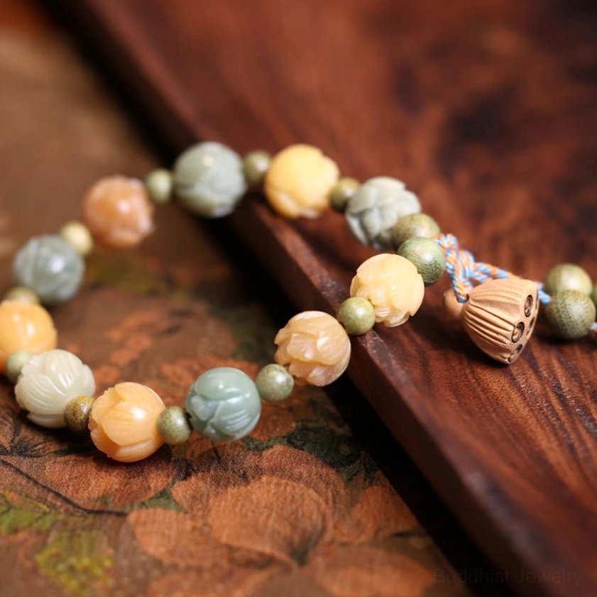 Bodhi seed lotus bracelet with carved floral beads and half-lotus pendant charm on dark wooden surface