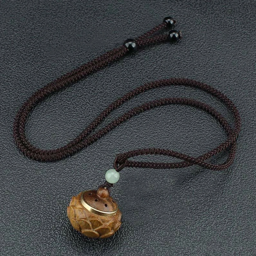 Flower-shaped green sandalwood Buddhist pendant necklace with carved details and spiritual symbolism on braided adjustable rope