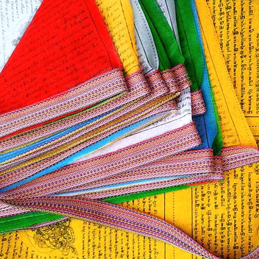 Folded multicolor Buddhist prayer flag set displaying woven edge trim, complete Tibetan Buddhist scriptures, and full collection of 25 flags with Lungta symbol