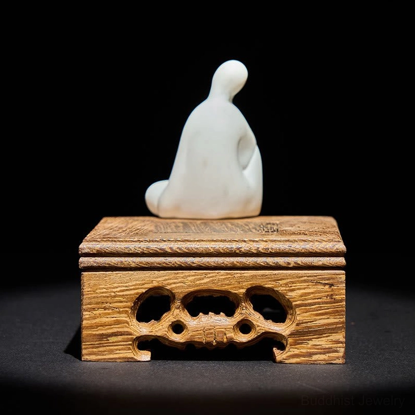 Buddhist ceramic Buddha figure with intricate wooden stand rear view, showing carved hollow details and spiritual symmetry
