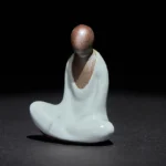 Formless Buddha meditating ceramic statue front view with two-tone brown and cyan glaze finish
