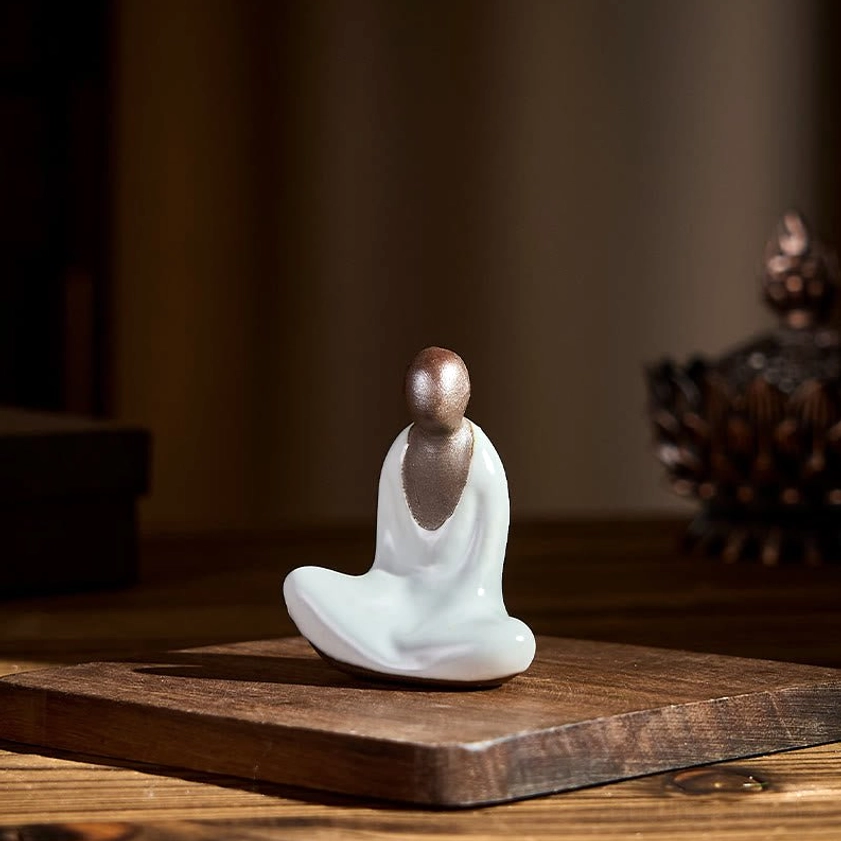 Compact ceramic Buddha statue on square wooden mat showing miniature scale and design