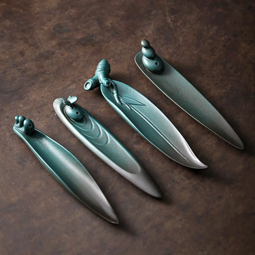 Four Buddhist ceramic incense holders collection flat lay overhead view showing Three Stones Waves Butterfly Bamboo designs