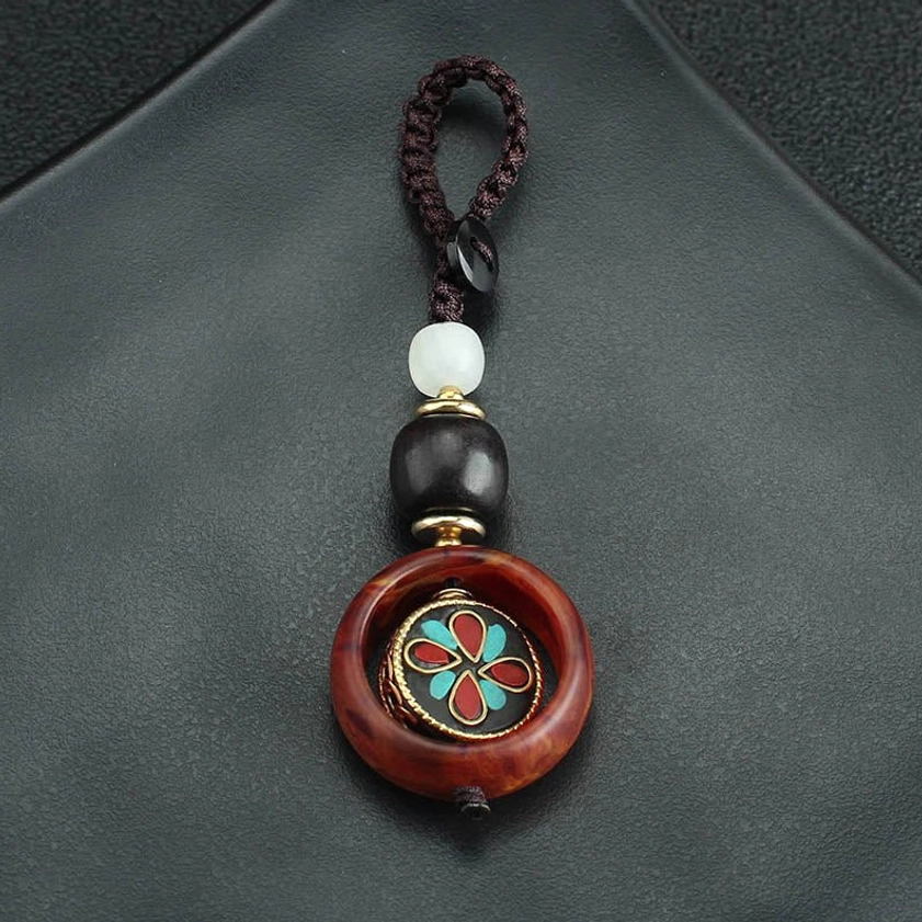 Close-up detail of rotating four-leaf clover charm keychain showing craftsmanship and spiritual design elements