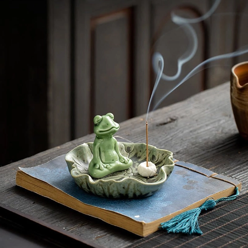 Frog incense burner decoration on wooden desk with vintage book and incense smoke atmosphere