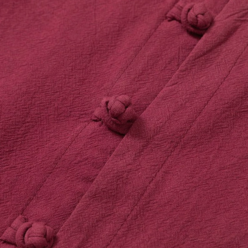 Texture and frog button closure detail on Buddhist meditation clothing, burgundy cotton fabric