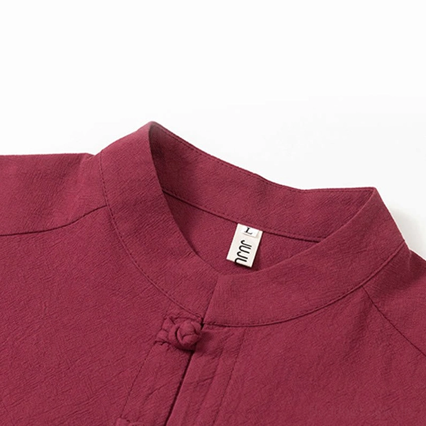Close-up detail of frog button collar and size label on Buddhist meditation shirt, burgundy cotton