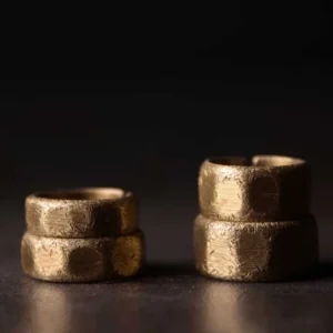 Two frosted copper brass adjustable wealth rings in different widths displayed front view showing hammered matte texture