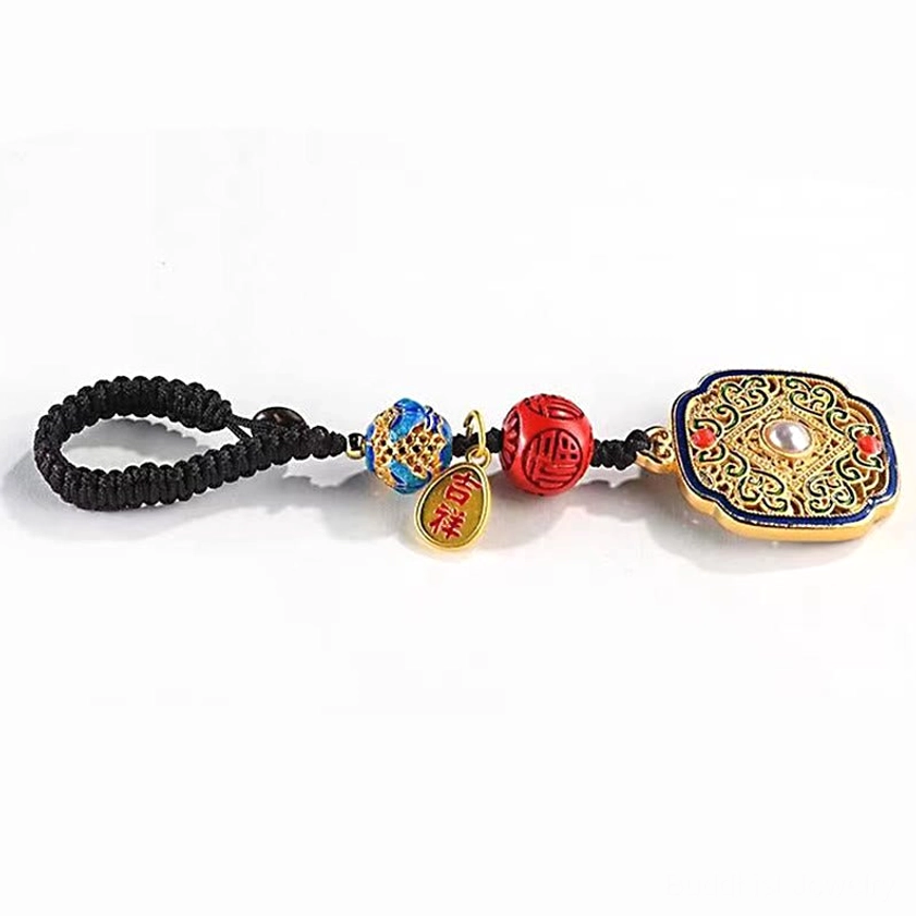 Buddhist Fu character blessing keychain with pearl-inlaid pendant auspicious metal tag and black braided cord on white background