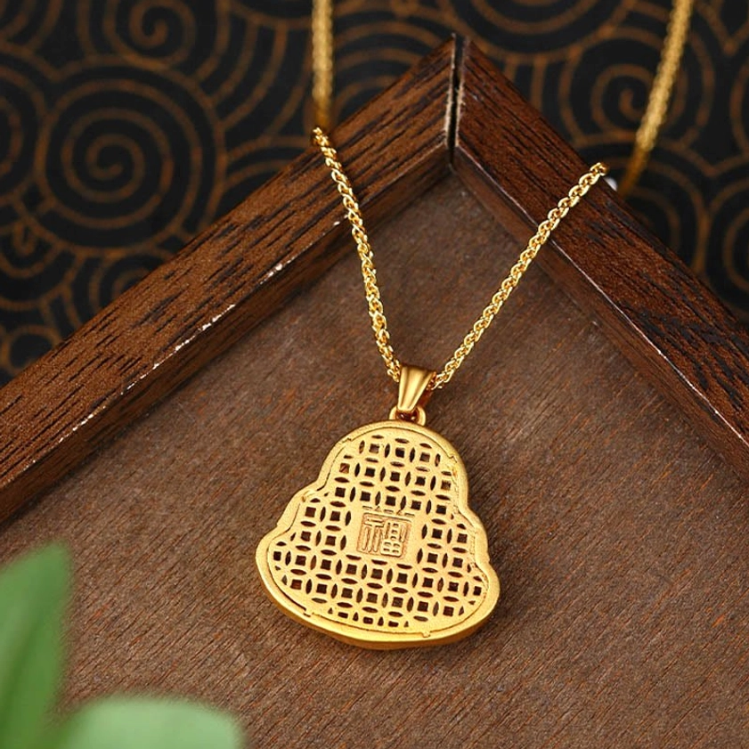 Fu character lattice carving on reverse side of Laughing Buddha gold pendant for prosperity and good fortune