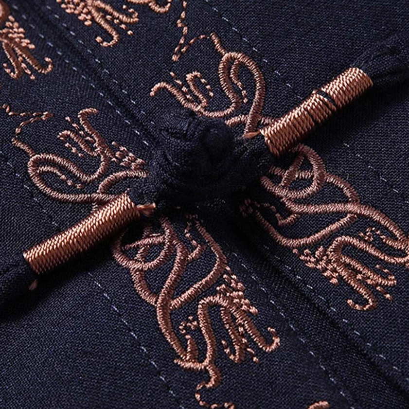 Macro view of bronze embroidered Fu character and silk frog button fastener on Tang suit jacket