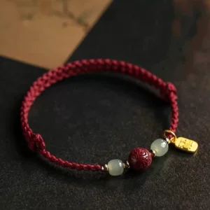 Fu character Hetian jade Om Mani Padme Hum red string prosperity bracelet with gold charm flat lay