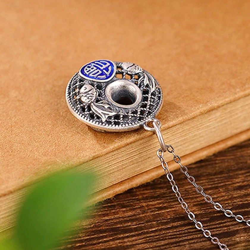 Silver fu character peace buckle pendant top down view with attached necklace chain on wooden desktop