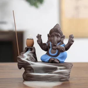 Ganesha backflow incense burner with blue deity figure on purple clay base, showing cascading aromatic smoke waterfall effect