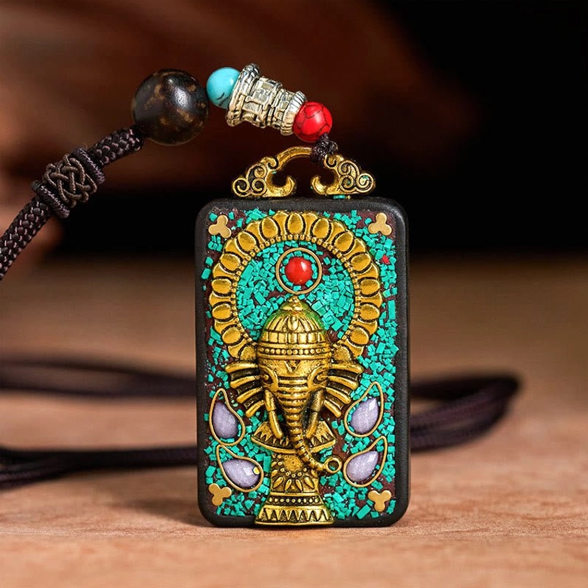 Left side angle of Ganesha pendant necklace with black braided rope and decorative metal beads