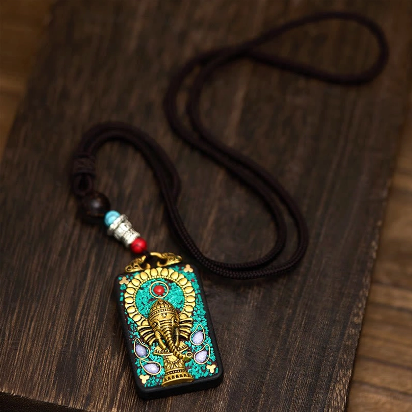 Full coiled Ganesha pendant necklace on dark wooden table surface