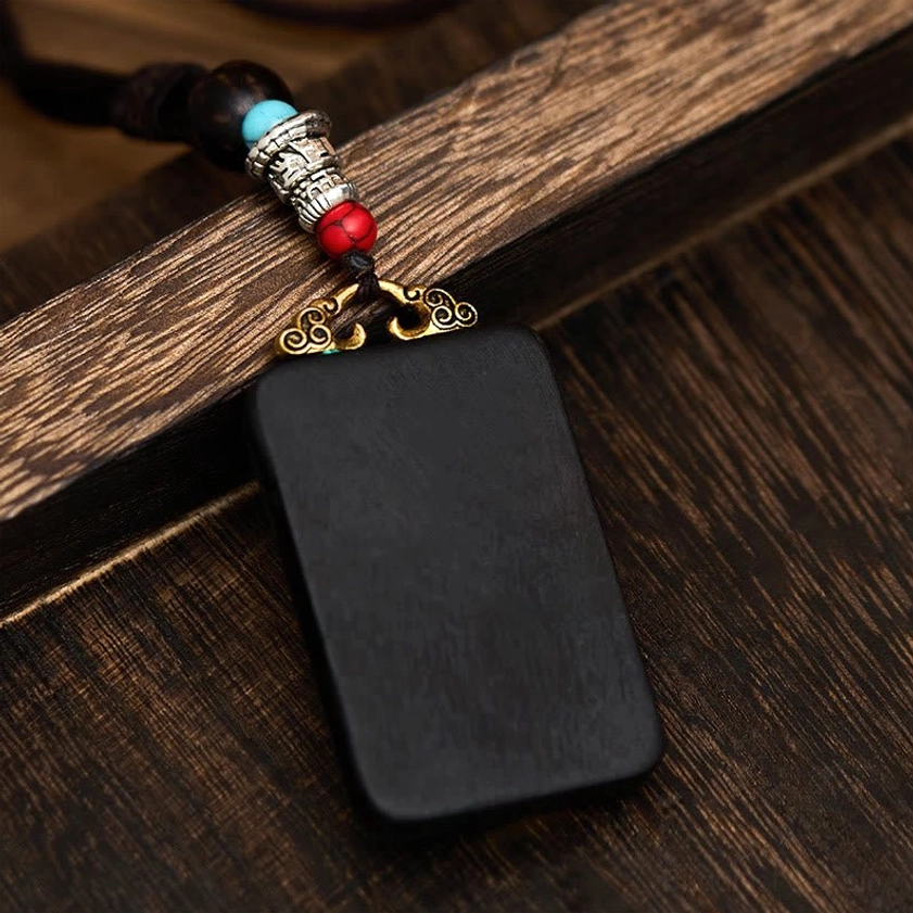 Back view of Ganesha wooden pendant necklace showing solid ebony wood construction and hanging rope cord