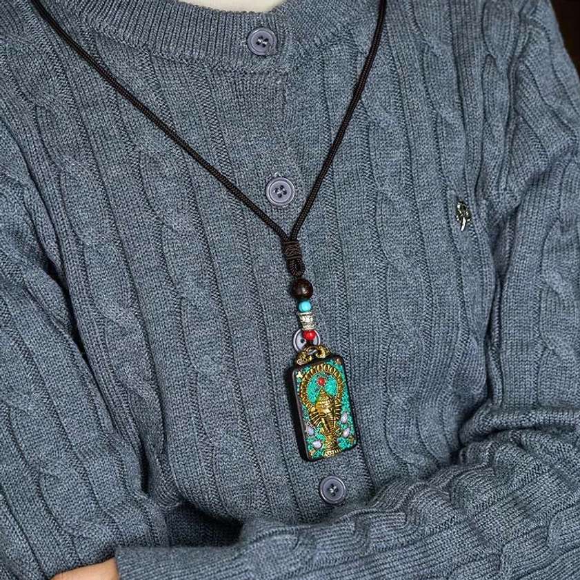 Wearing demonstration of Ganesha elephant pendant necklace on person in gray knitted sweater