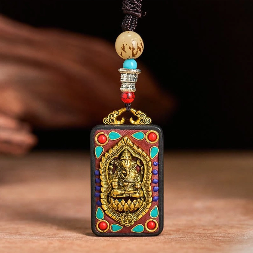 Ganesha wooden pendant showing natural ebony texture and spiritual carved details