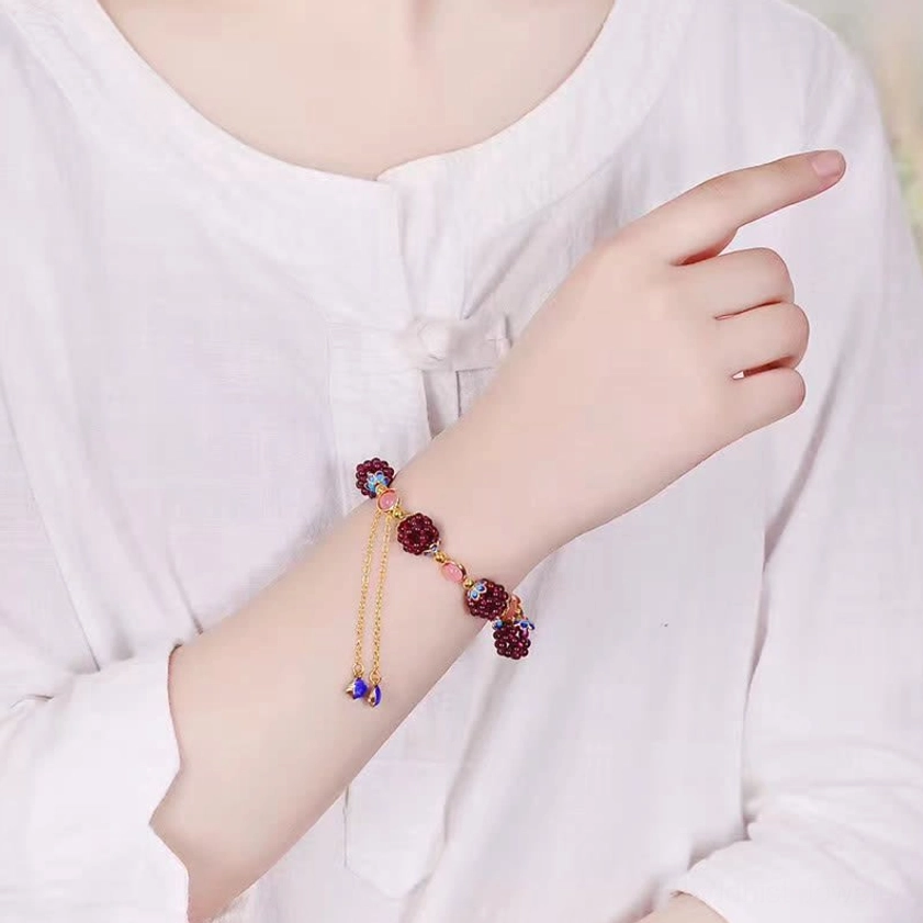 Dainty garnet amethyst Buddhist bracelet with adjustable chain worn on wrist with white shirt