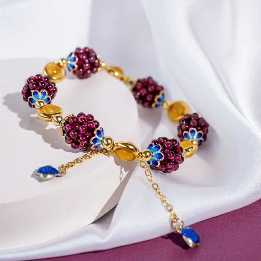 Two matching garnet amethyst Buddhist bracelets with gold hardware on white silk cloth