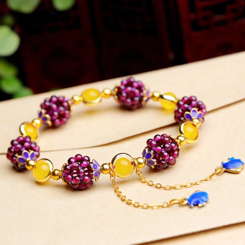 Mixed gemstone garnet amethyst bracelet with adjustable extender chains and enamel decorative accents on light background