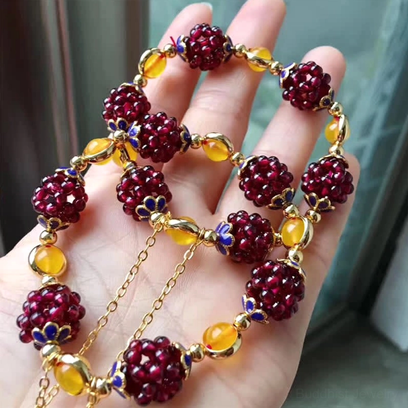 Multiple handmade garnet amethyst Buddhist bracelets showcasing color variations and beadwork