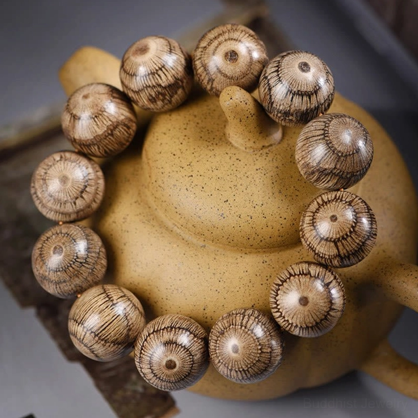 Close-up side view of gnetum wood beaded bracelet displaying striped radial texture on authentic Buddhist protection beads