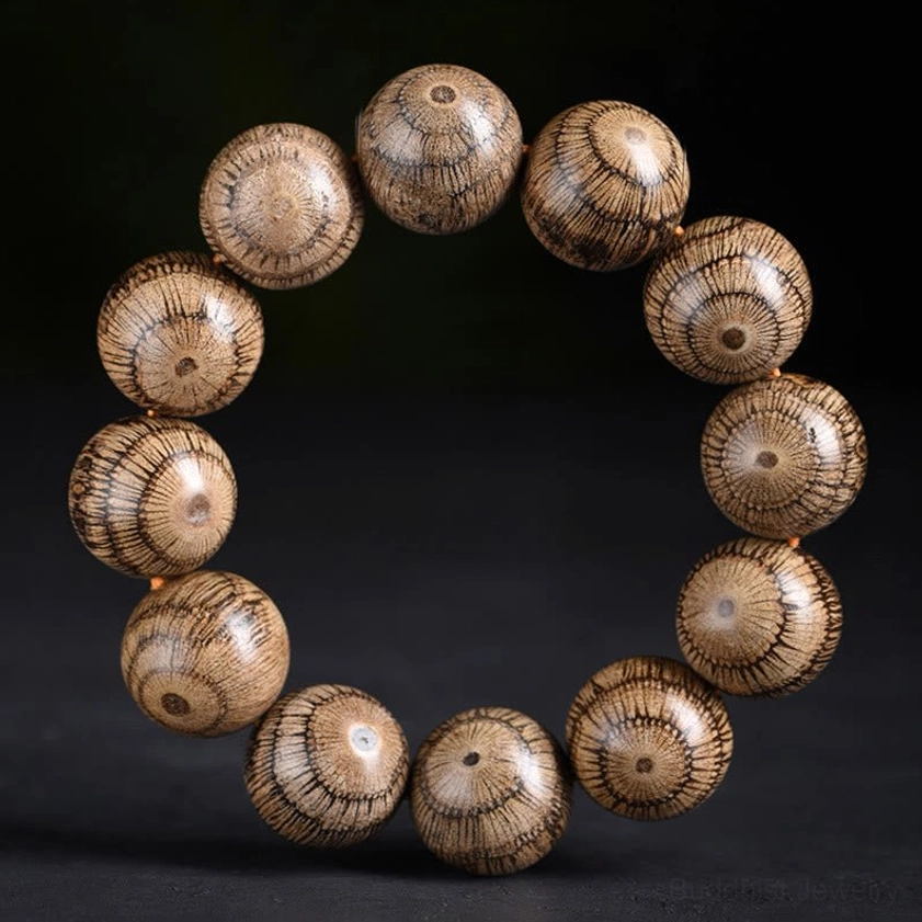 Gnetum wood beads Buddhist bracelet for protection - flat lay top view showing radial grain pattern on natural wood beads