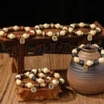 Goddess of Wealth liuli glass and incense ash porcelain bead bracelets displayed on carved wooden stands with pottery decor